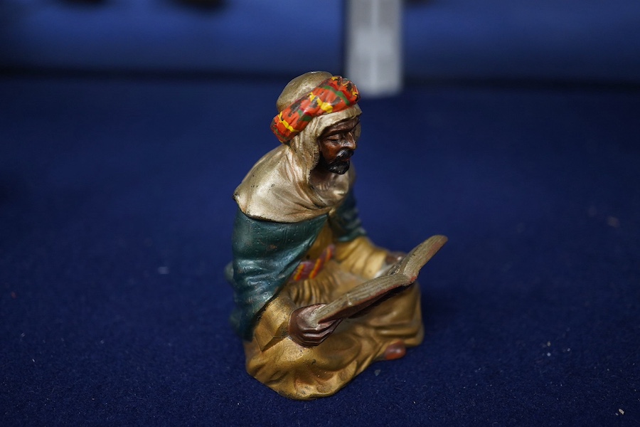 A modern cold painted bronze seated Arab reading, 8cm high. Condition - good